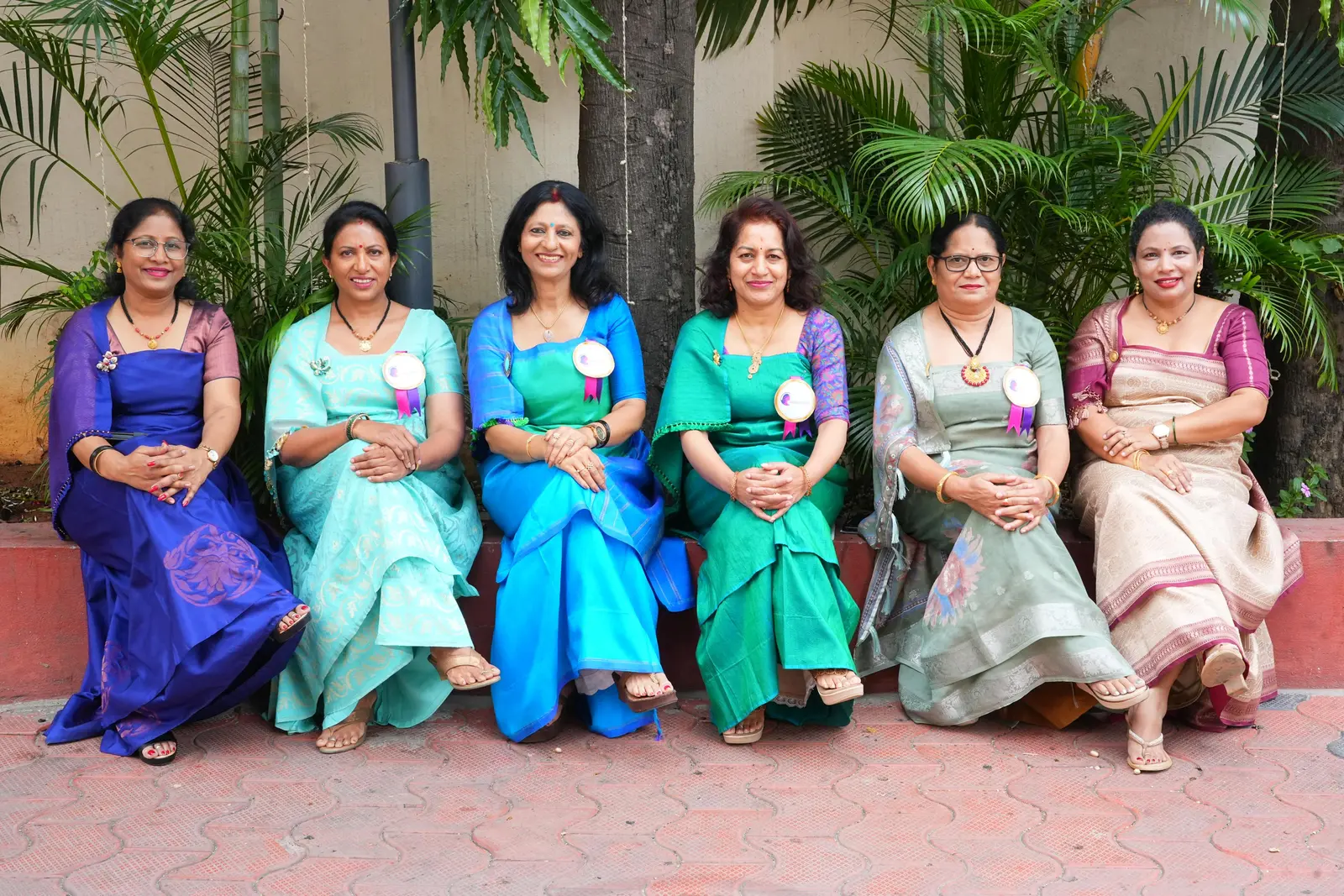 Six members of the Kodava Samaja Women’s Council seated together outside the Samaja